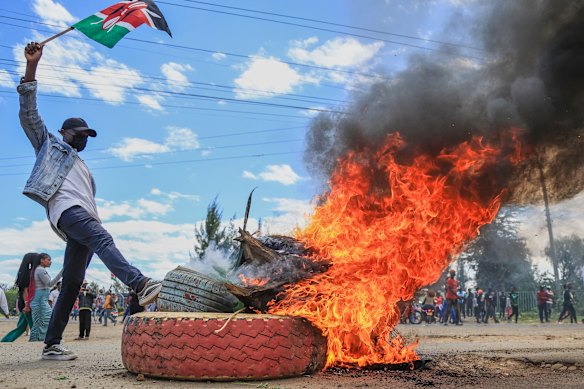 A protester near a burning barricade during a demonstration against a proposed Ebola quarantine centre in Nanyuki, Kenya. The Ebola response has been hampered by protests and conspiracy theories.